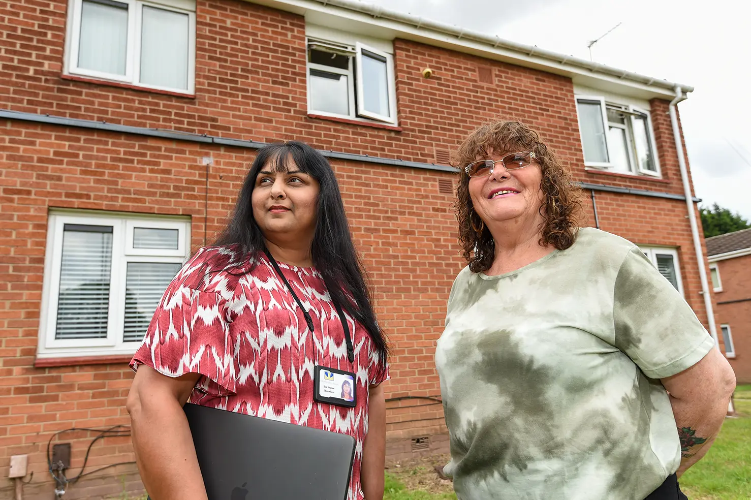 A customer and a Wolverhampton Homes team member outside a low-rise flat