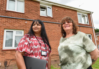 A customer and a Wolverhampton Homes team member outside a low-rise flat