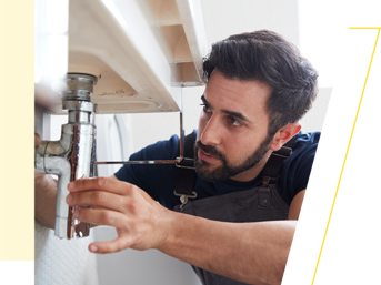 A plumber fixes a leak on a sink