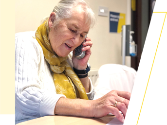 A woman in a yellow scarf, speaking on the telephone