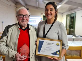 A customer receives a certificate and award from a Wolverhampton Homes team member