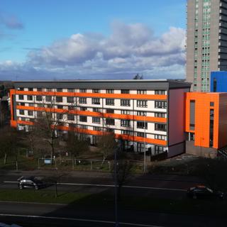 A low-rise block of flats with orange facade 
