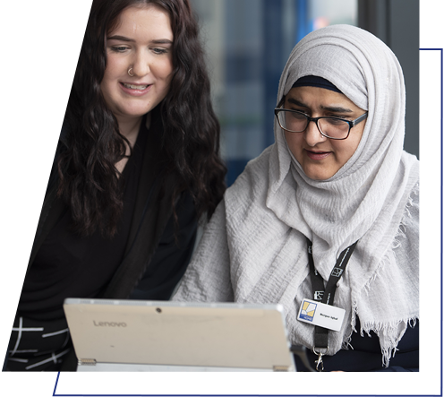 Two members of staff working from a laptop