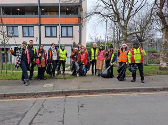 A group of 13 people wearing hi-vis jackets, Santa hats and festive scarves at Heath Town