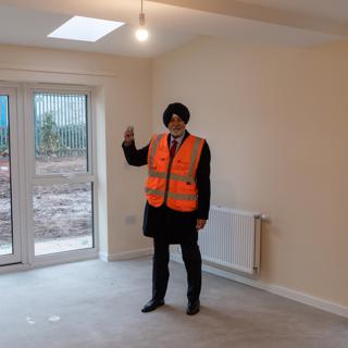 A man stands holding keys inside one of the new-build properties