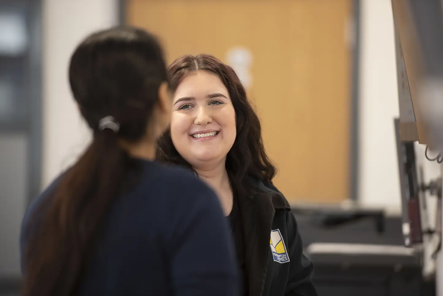 A Wolverhampton Homes team member smiles at a colleague