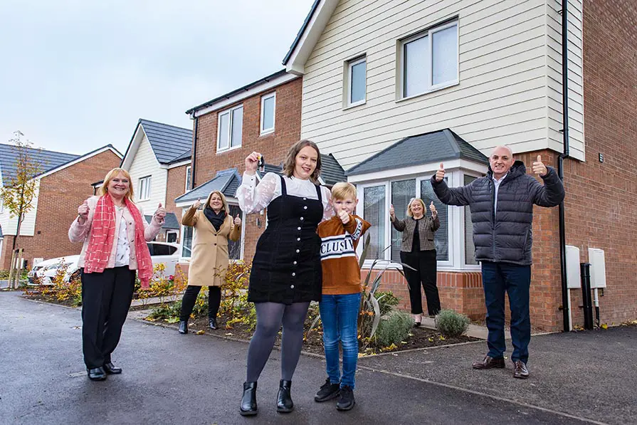 A woman and her son receive the keys to her new home, surrounded by Wolverhampton Homes team members