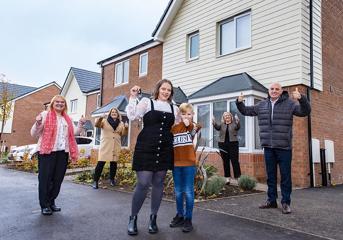 A woman and her son receive the keys to her new home, surrounded by Wolverhampton Homes team members