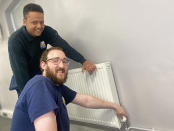 Two Wolverhampton Homes apprentices check a radiator
