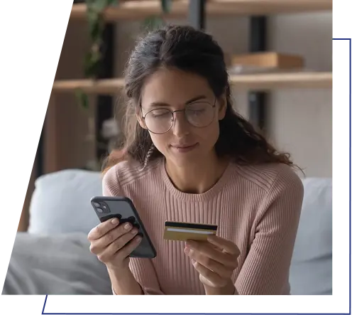 Woman holding a credit card, looking like she is paying for something on her phone