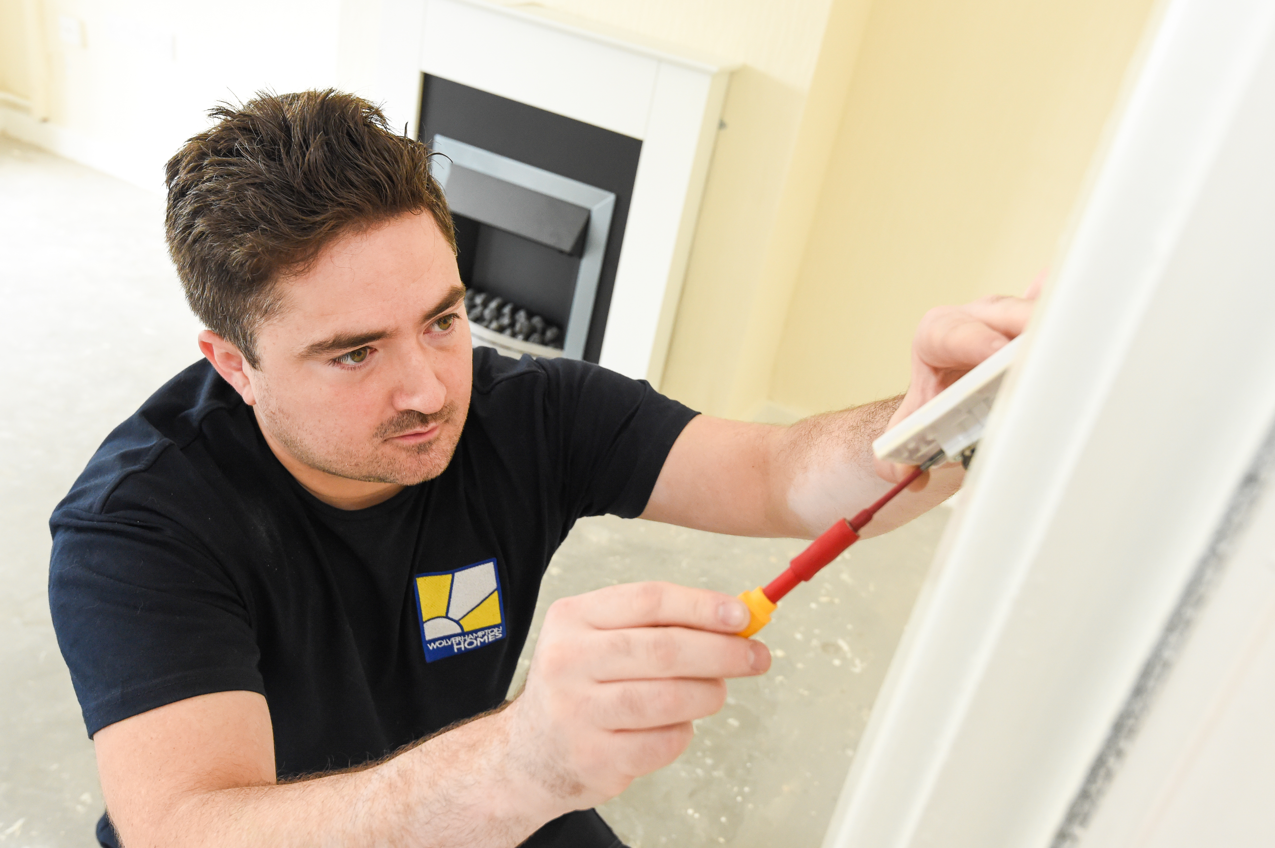 A Wolverhampton Homes electrician checks a light switch