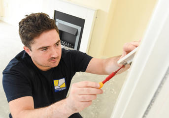 A Wolverhampton Homes electrician checks a light switch
