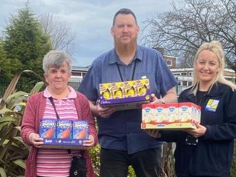 Three people holding Easter eggs outdoors