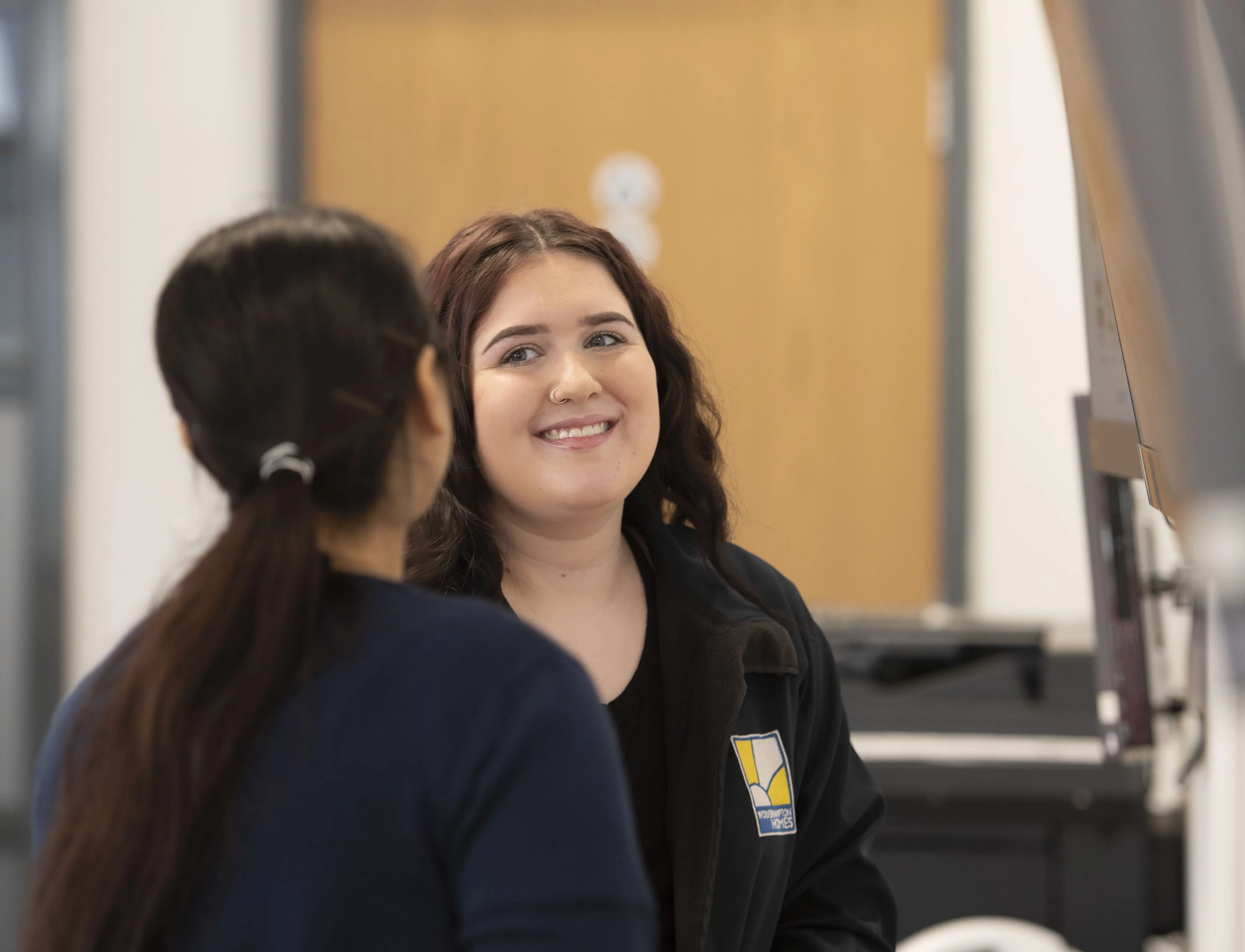 A Wolverhampton Homes team member smiles at a colleague