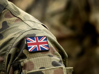 A soldier' wearing camouflage, with a Union flag badge on his shoulder