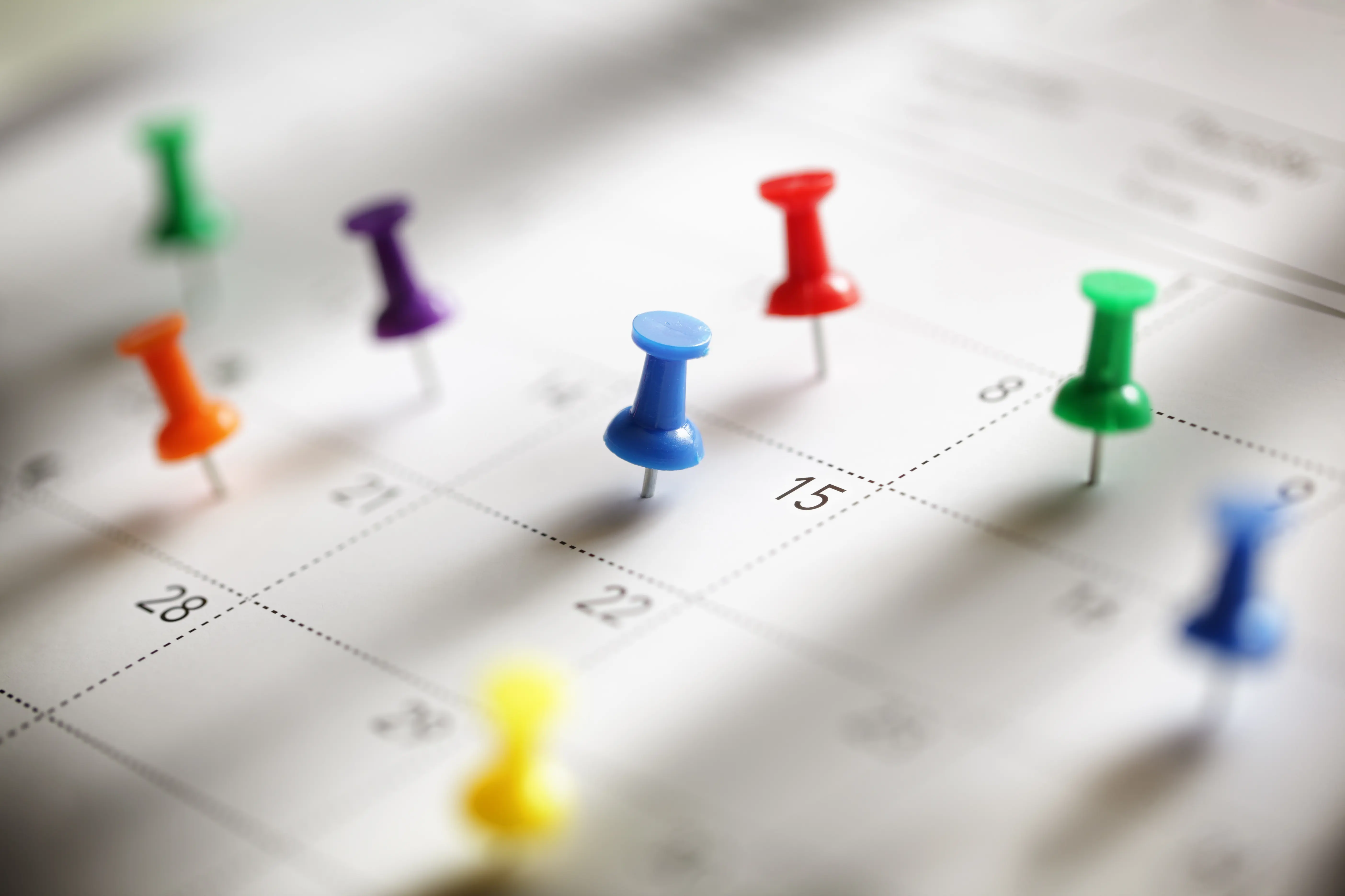A calendar with lots of pins in dates