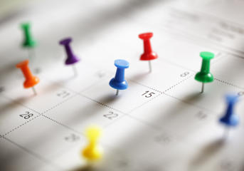 A calendar with lots of pins in dates
