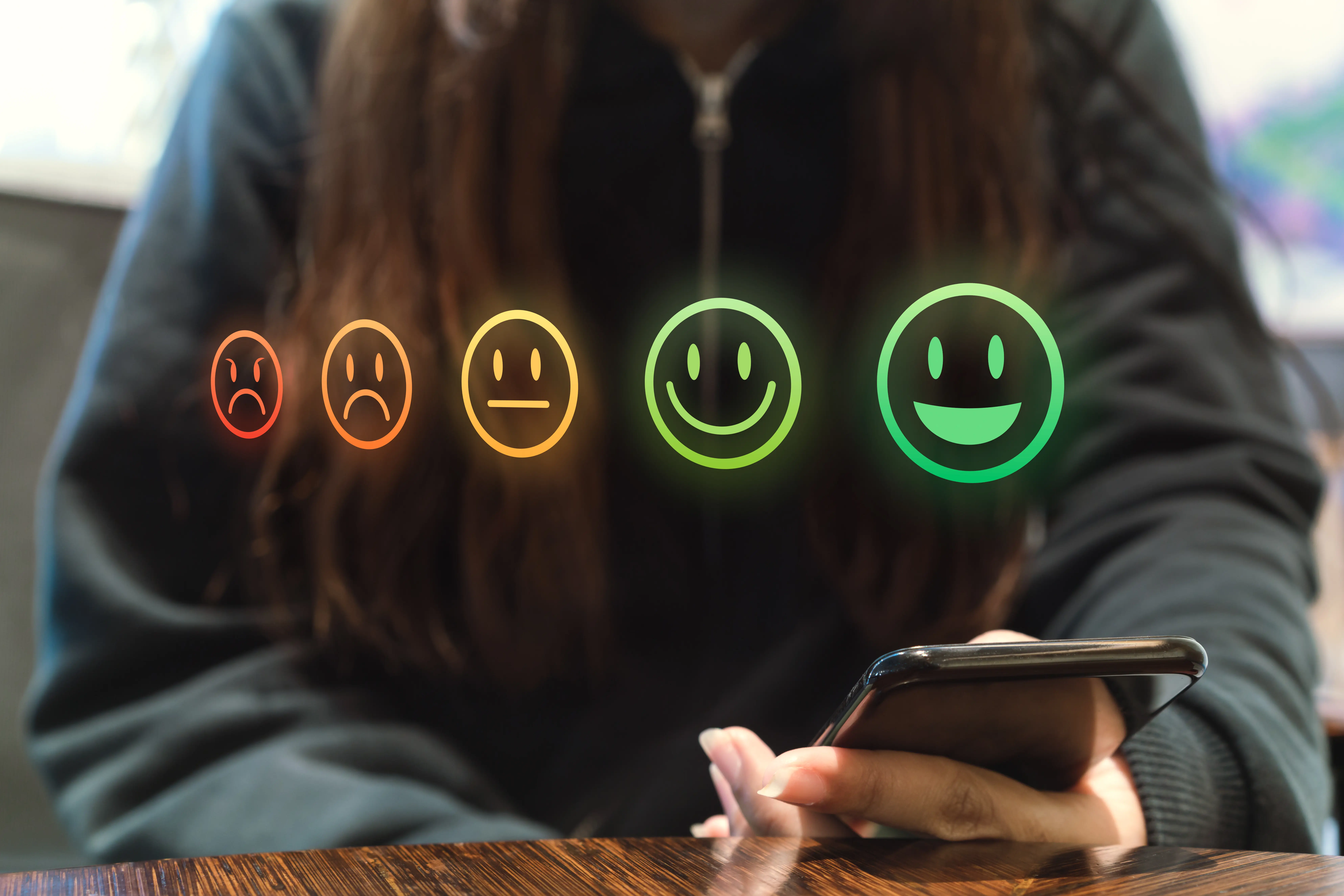 Stock image of five emojis with smiley faces to sad faces 