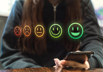 Stock image of five emojis with smiley faces to sad faces 