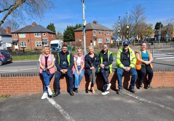 A group of seven people from Wolverhampton Homes and United Living, sitting on a wall after litter picking in Oxley
