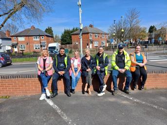A group of seven people from Wolverhampton Homes and United Living, sitting on a wall after litter picking in Oxley