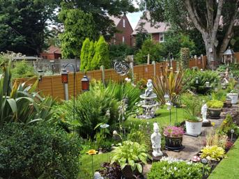 Landscaped garden with flower beds, lawn and garden ornaments