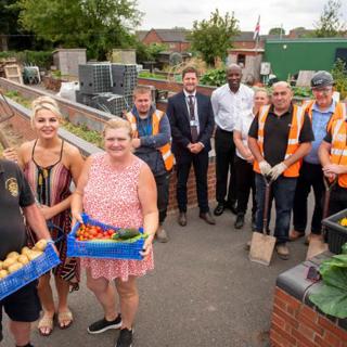 Howell Street Allotments - people holding baskets of produce, with onlookers 