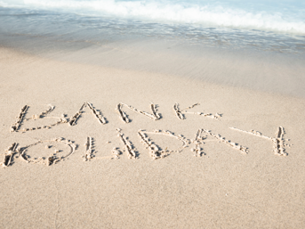 The words 'Bank Holiday' written in the sand on a beach