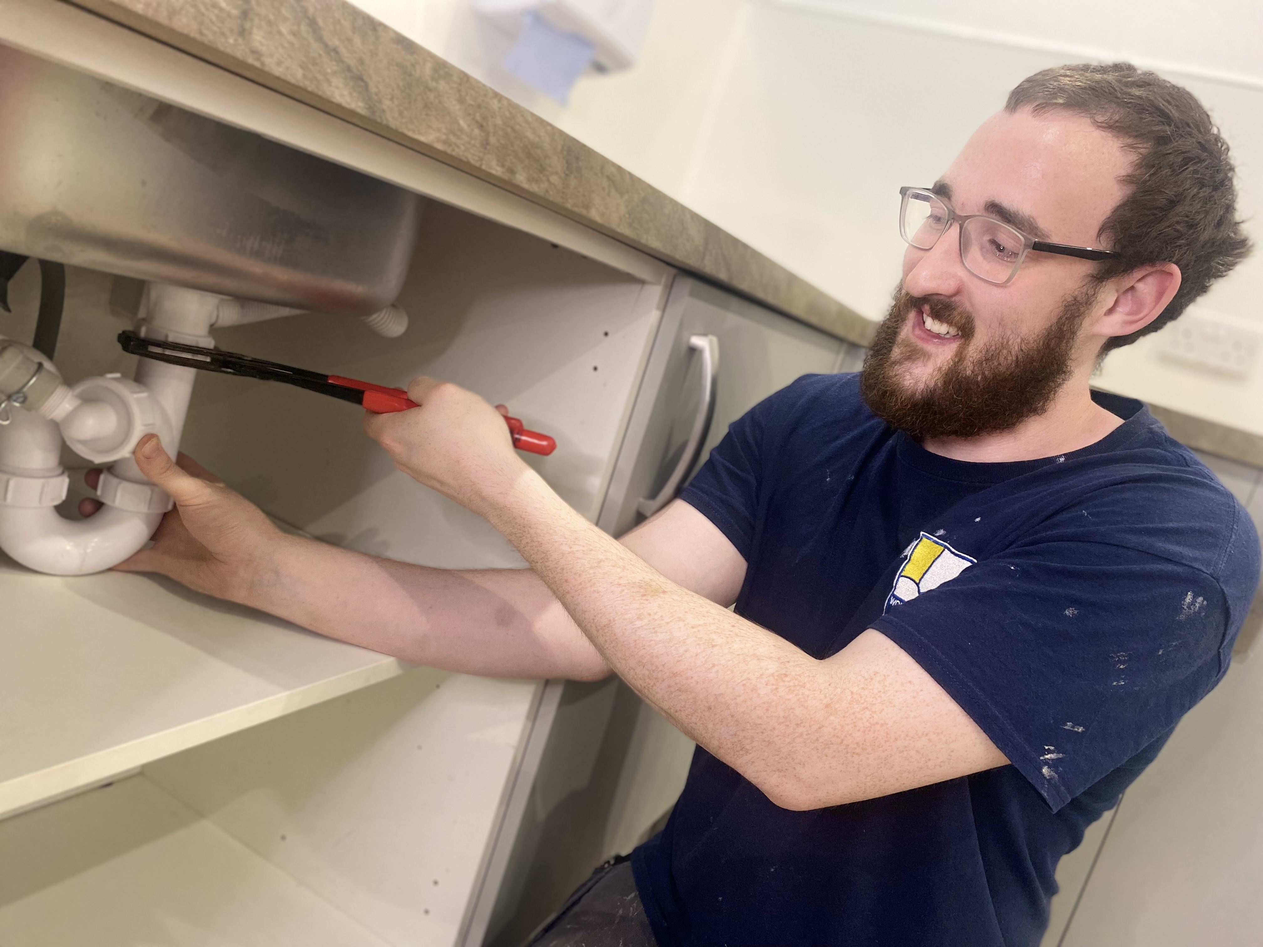 A Wolverhampton Homes apprentice fixes a sink