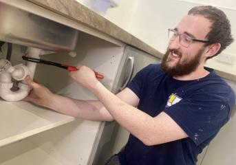 A Wolverhampton Homes apprentice fixes a sink