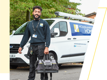 A Wolverhampton Homes operative holding a bag and standing by a WH van