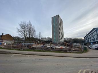 Building works begin, with a block of flats behind