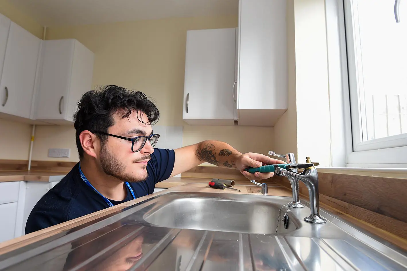 A Wolverhampton Homes plumber mends a kitchen tap