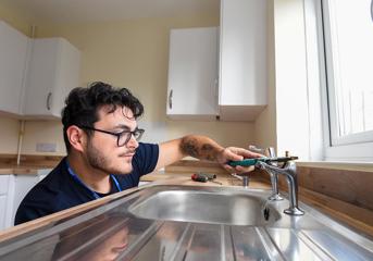 A Wolverhampton Homes plumber mends a kitchen tap