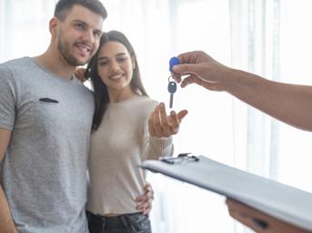 A man and a woman take the keys to a home