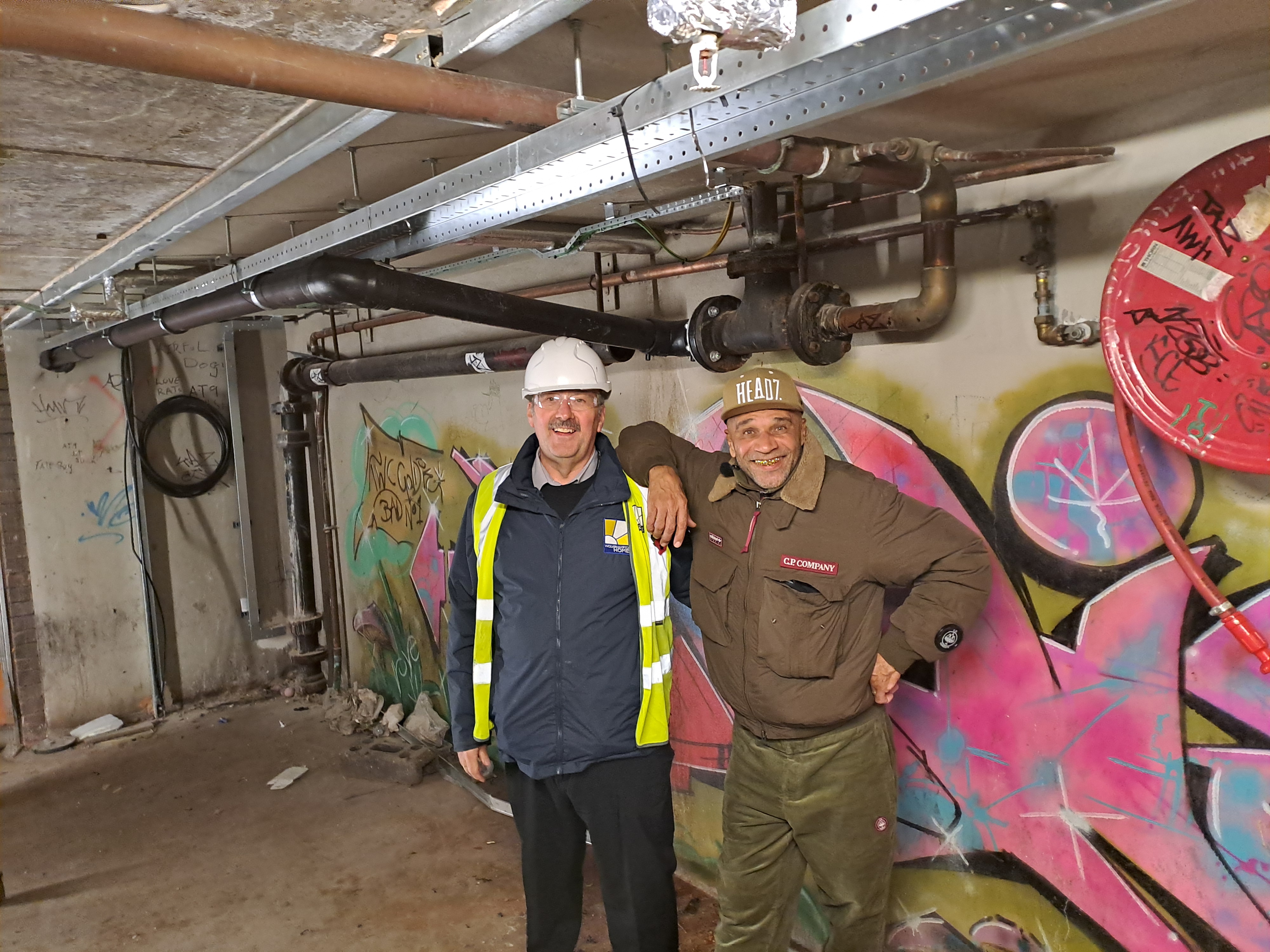 An image of two men near graffiti 