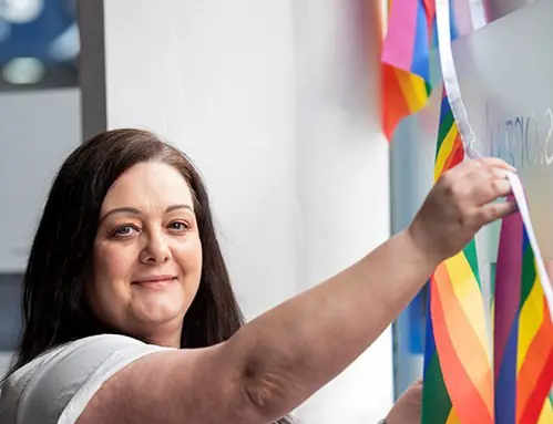 A Wolverhampton Homes team member puts up bunting for Wolverhampton Pride