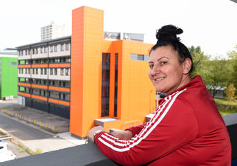 A Wolverhampton Homes customer stands on a walkway at flats in Heath Town 