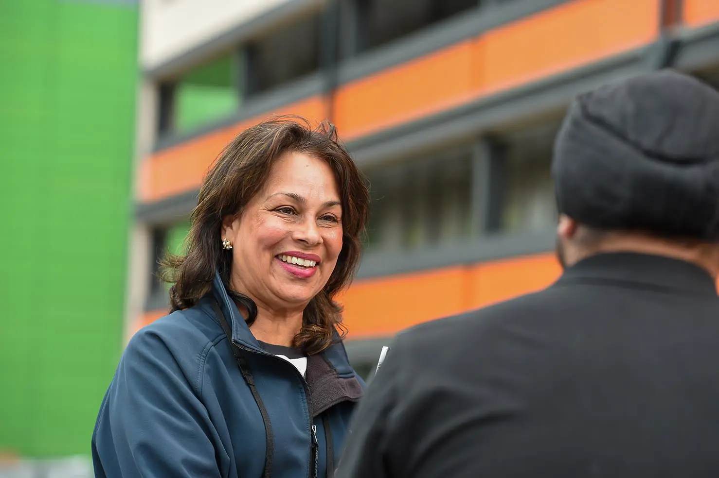 A Wolverhampton Homes team member talks to a tenant outside flats