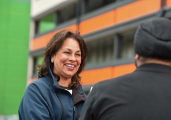 A Wolverhampton Homes team member talks to a tenant outside flats