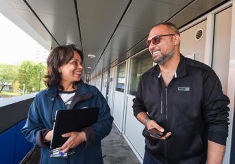 A Wolverhampton Homes team member talks to a tenant on a walkway at a block of flats