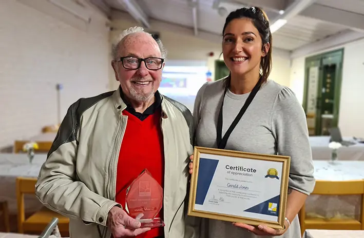 A male customer receives a certificate and award from a Wolverhampton Homes team member 