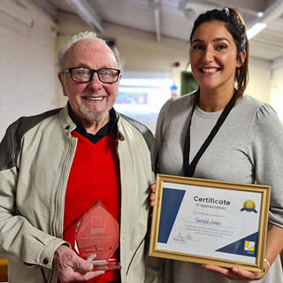 A male customer receives a certificate and award from a Wolverhampton Homes team member 