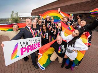 Group of people holding rainbow flags at a Pride event
