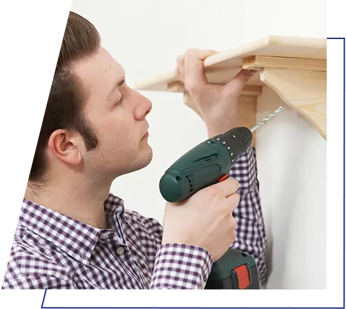 An image of a man putting up a shelf with a drill